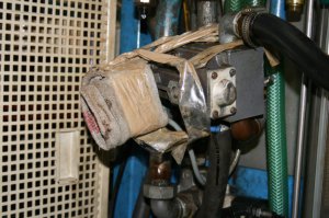 Cette photo représente un exemple typique de réparation de fortune (patch, plaster) devenue permanente. On distingue une valve pneumatique non fixée, dont une guenille a été attachée  sur les silencieux (muffler) avec du papier collant afin d’empêcher l’huile contenue dans l’air de contaminer les produits. 